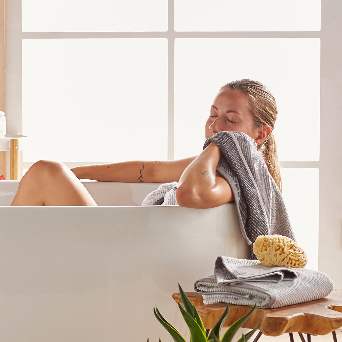 Woman in bath tub relaxing with towels